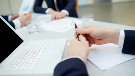 Reunião corporativa com executivos analisando documentos e estratégias de negócios