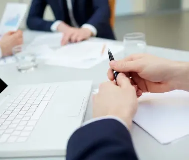 Reunião corporativa com executivos analisando documentos e estratégias de negócios