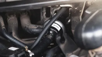 Mangueira de abastecimento GNV conectada a um carro adaptado para receber o combustível.