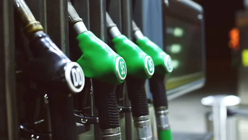 Mangueiras das bombas de combustíveis com sinalização verde e preta e conectadas a um tanque de combustível subterrâneo