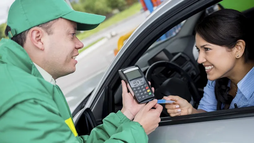 Vendedor segurando uma máquina de pagamento em cartão e seguindo um script de vendas para prestar um atendimento de qualidade ao cliente em um posto.