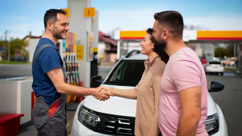 pessoas apertando as mãos no posto de gasolina