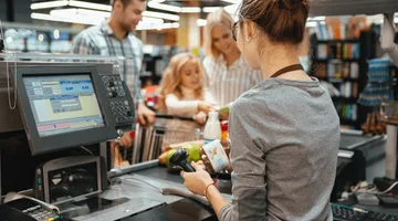 Produtos para loja de conveniência: imagem de uma moça trabalhando no caixa de uma loja em um posto de gasolina