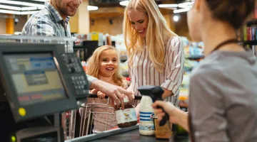 Tendências para lojas de conveniência: imagem de uma família passando no caixa