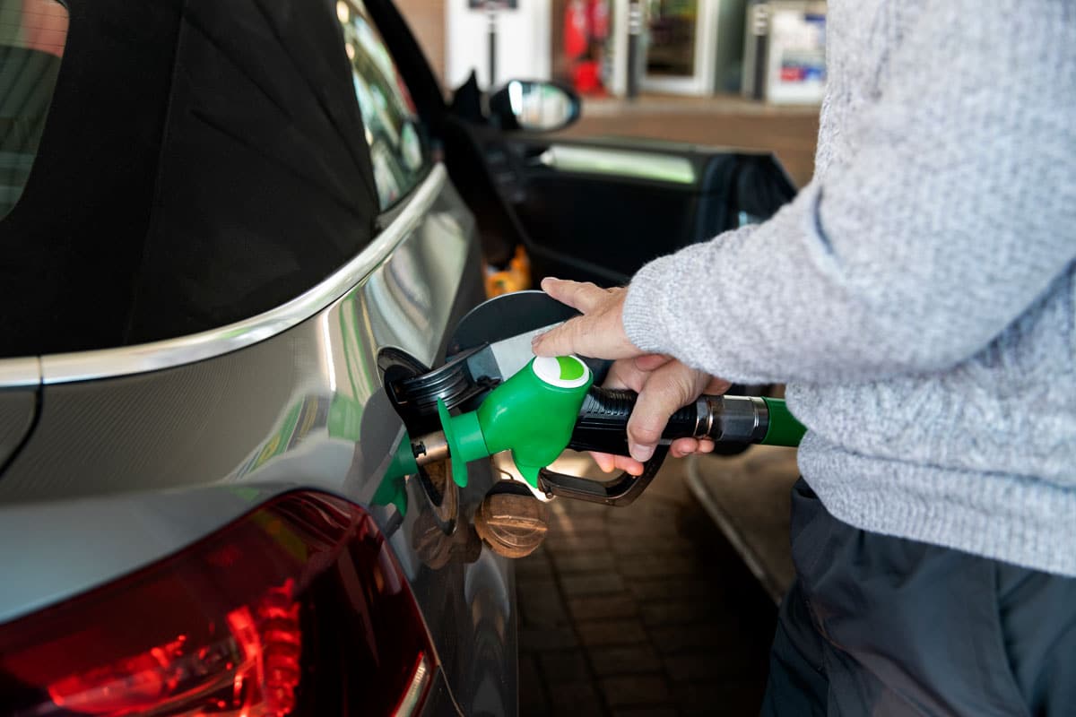 Homem abastecendo seu carro em posto de combustíveis para representar os benefícios de contar com um programa de fidelidade para descontos e cashback.