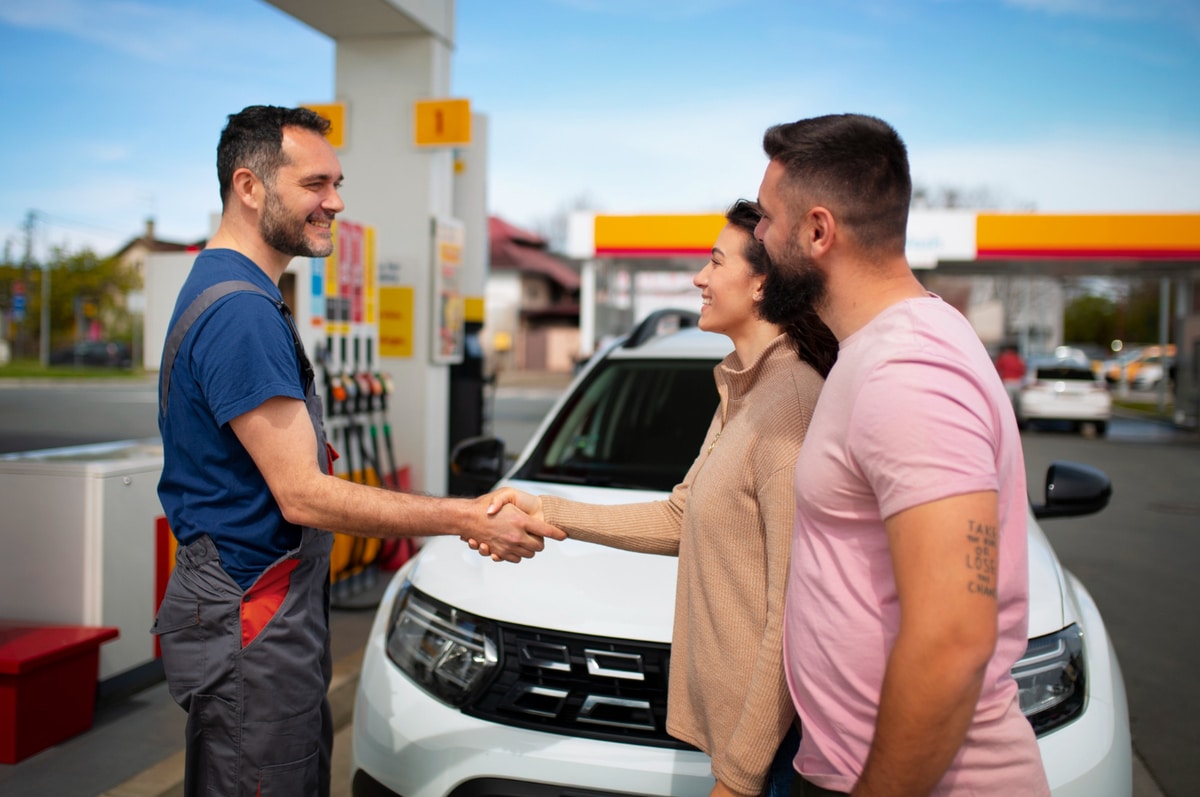 pessoas apertando as mãos no posto de gasolina