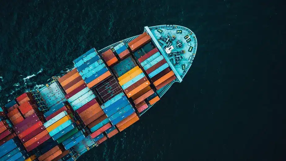 Navio cargueiro transportando contêineres em rota marítima internacional