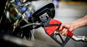 Pessoa abastecendo veículo com bico de combustível em posto